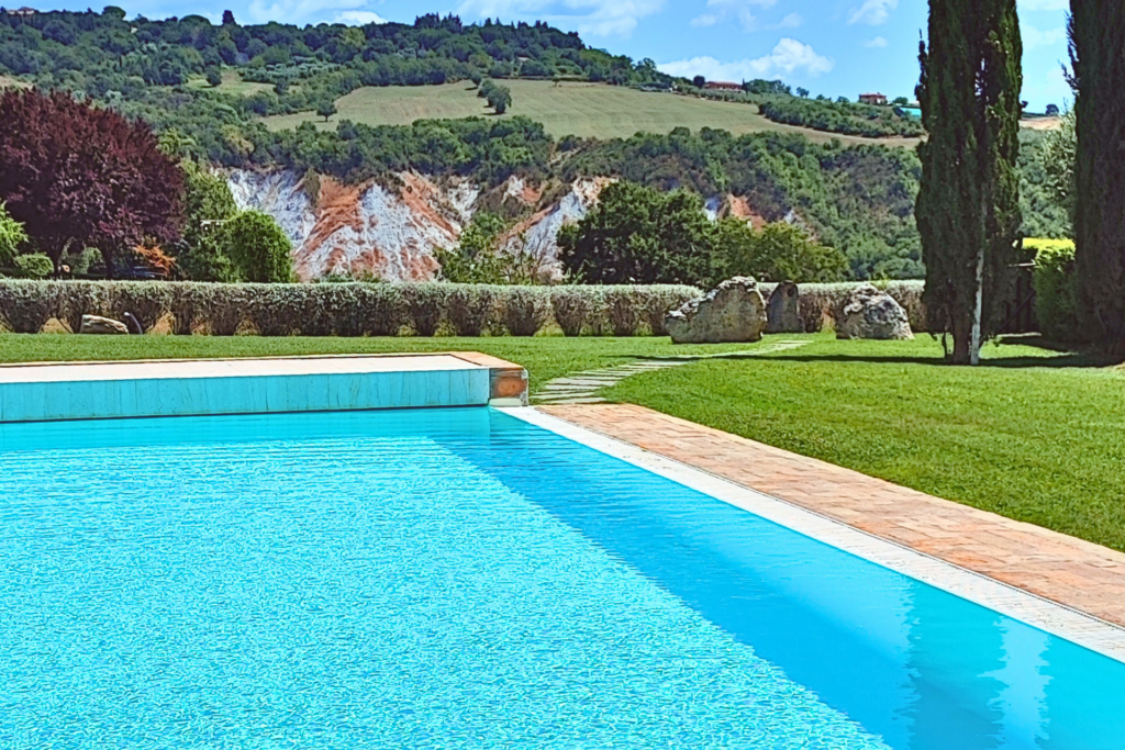 Salt-water pool at Seme di Carota agriturismo, with the hills of Saturnia in the background