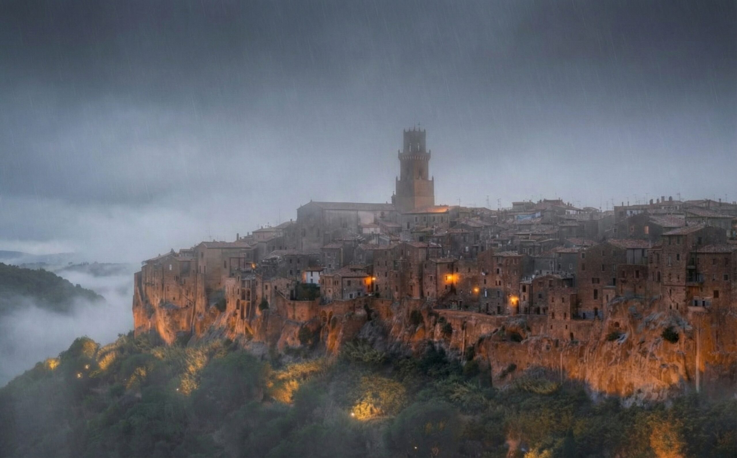 Il borgo di Pitigliano scavato nel tufo avvolto dalla nebbia in una giornata d'autunno in Maremma